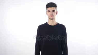 Mutluluktan gülümseyen genç adam beyaz arka planda izole edilmiş kameraya bakıyor.