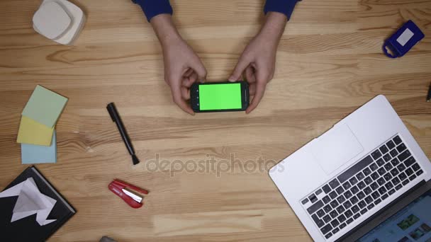 Χρησιμοποιώντας τηλέφωνο Android που τοποθέτηση ξύλινο τραπέζι στο σπίτι. Το Top View. Αιτιώδη τρόπο ζωής — Αρχείο Βίντεο