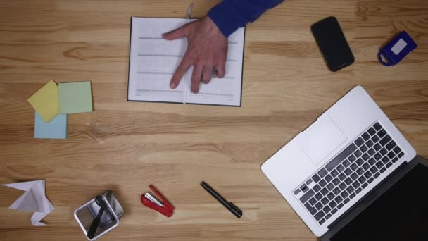 El hombre escribe en el portátil y escribe notas. Freelancer trabajando en la oficina. Hombre de negocios y ordenador — Vídeo de stock