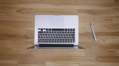 Ofis Masası evrak ve diğer nesnelerin çevresine, üstten görünüm ile bir dizüstü bilgisayar üzerinde çalışan iş adamı