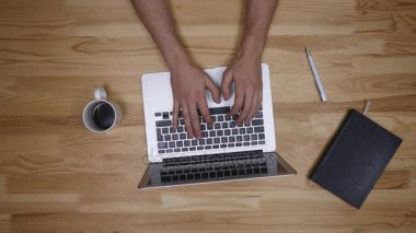 Onun laptop ile ahşap bir zemin üzerinde çalışan adam