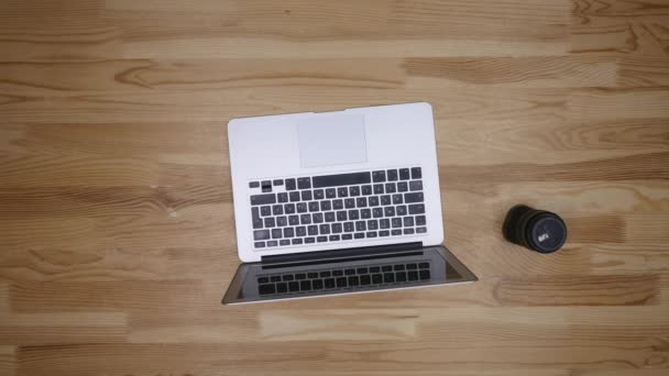 職場写真家の平面図です。コンピューターで作業し、コーヒーを飲む男。木製の背景に完璧主義の精神におけるアイテムのレイアウトします。 — ストック動画
