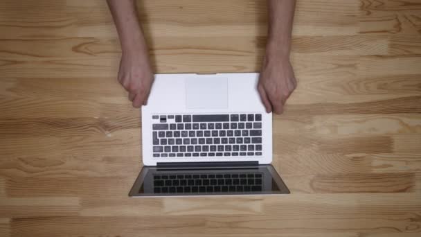 Vista superior del fotógrafo del lugar de trabajo. Un hombre trabajando en la computadora y bebiendo café. Los artículos están dispuestos en el espíritu del perfeccionismo sobre un fondo de madera — Vídeos de Stock