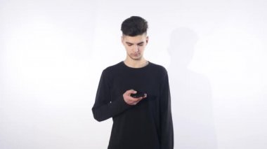 Cep telefonunuza konuşan şaşkın şaşkın genç adam. Adam portre düşünme ve telefon konuşma