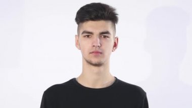 Güven eksikliği. Utangaç genç yakışıklı adam garip izole üzerinde gri duvar arka plan geliyor. İnsani duygular beden dili yaşam algı