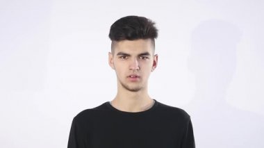 Güven eksikliği. Utangaç genç yakışıklı adam garip izole üzerinde gri duvar arka plan geliyor. İnsani duygular beden dili yaşam algı