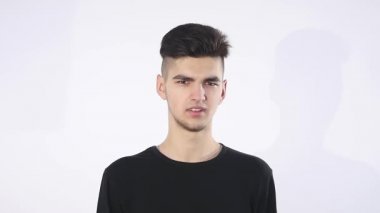 Güven eksikliği. Utangaç genç yakışıklı adam garip izole üzerinde gri duvar arka plan geliyor. İnsani duygular beden dili yaşam algı