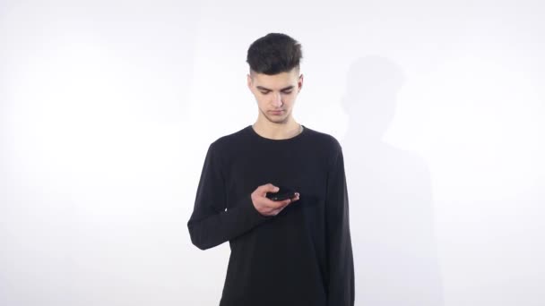 Zmatený zmatená mladý muž v rozhovoru pro mobilní telefon. Muž portrét myšlení a mluvení do telefonu — Stock video