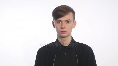 Beyaz arka plan üzerinde duran ve iğrenme yüzünde gösterilen yakışıklı delikanlı