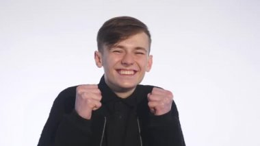 Kendine güvenen genç adam beyaz arka plan üzerinde gülümseyen