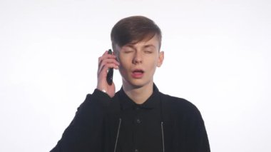 Çekici bir genç adam onun telefonda konuşurken portresi. İzole beyaz arka plan