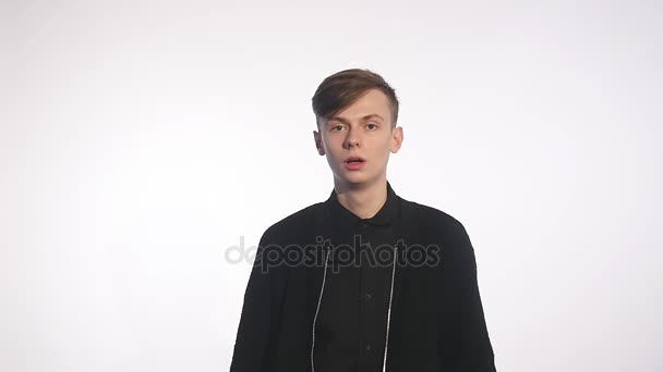 This is amazing Surprised young man in casual shirt keeping mouth open and staring at camera while standing against white background — Stock Video