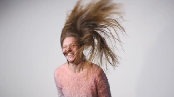 Giovane bella ragazza caucasica agitando i capelli e la testa sorridente su sfondo bianco al rallentatore — Video Stock