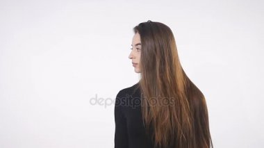 Gri arka planda güzel bir kız ağzını kapatıyor.