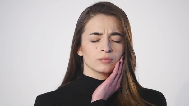 Mulher adolescente pressionando sua bochecha machucada com uma expressão dolorosa como se ela tivesse uma dor de dente terrível — Vídeo de Stock