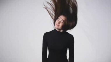 Genç güzel beyaz kız dalgalanan saç ve kafa slowmotion olarak beyaz arka plan üzerinde gülümseyen