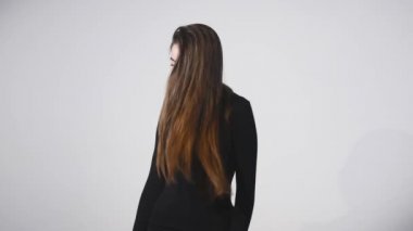 Genç güzel beyaz kız dalgalanan saç ve kafa slowmotion olarak beyaz arka plan üzerinde gülümseyen