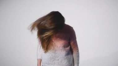 Genç güzel beyaz kız dalgalanan saç ve kafa slowmotion olarak beyaz arka plan üzerinde gülümseyen