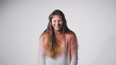 Genç güzel beyaz kız dalgalanan saç ve kafa slowmotion olarak beyaz arka plan üzerinde gülümseyen