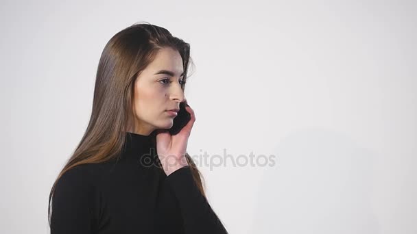 Close up de mulher em seu celular contra um fundo branco — Vídeo de Stock