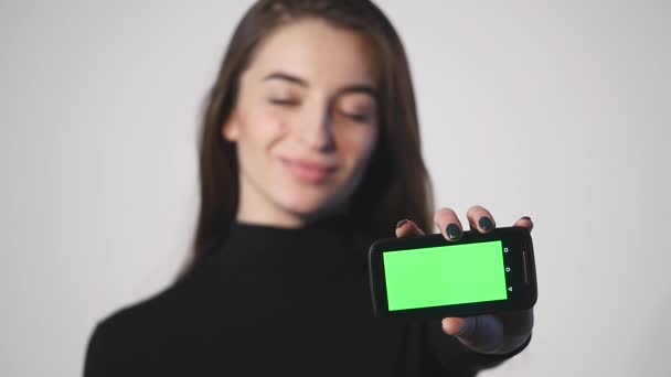 Young beautiful woman holding smartphone with copyspace - isolated on white background — Stock Video