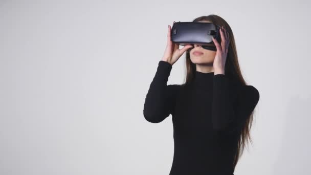 Женщина использует головной дисплей. Женщина в маске виртуальной реальности оглядывается вокруг — стоковое видео