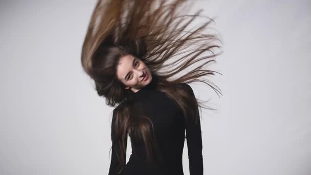 Unga vackra kaukasiska flicka viftande hår och huvudet leende på vit bakgrund i slowmotion — Stockvideo