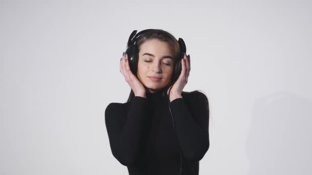 Молодая красивая кавказская девушка машет волосами и головой, улыбаясь на белом фоне в замедленном темпе — стоковое видео