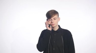 Cep telefonunuza konuşan şaşkın şaşkın genç adam. Adam portre düşünme ve telefon konuşma