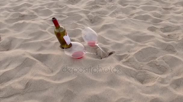 Láhev vína a skleničky na pláži v písku — Stock video