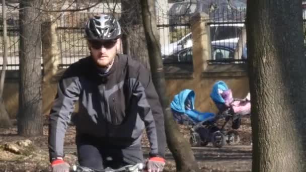 Le chemin parsemé de feuilles automnales, l'homme passant sur le vélo — Video