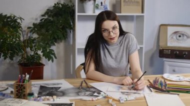 Kameraya bakarak güzel genç kadın ressam