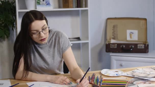 Giovane donna tiene una matita e disegna a casa — Video Stock