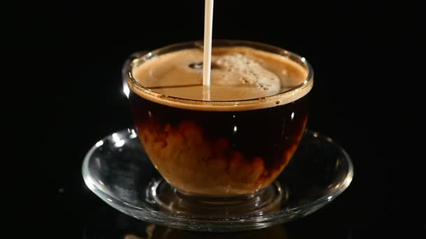 Gieten melk in een kopje koffie, close-up slow motion — Stockvideo