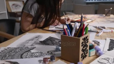 Genç kadın bir kalem tutan ve evde çizer