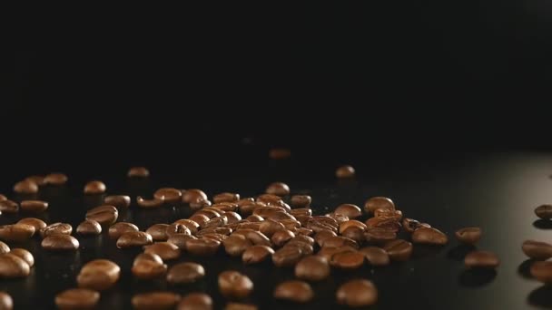 Grains de café - Chute. Une macro shot 96 FpS de grains de café tombant sur la surface noire. Un beau plan générique pour tous les thèmes liés au café ou arrière-plans de titre — Video