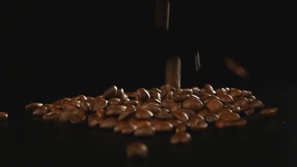 Feijões de café - Queda. Um macro shot de 96 FpS de grãos de café caindo na superfície preta. Um belo tiro genérico para qualquer tema relacionado com o café ou fundos de título — Vídeo de Stock