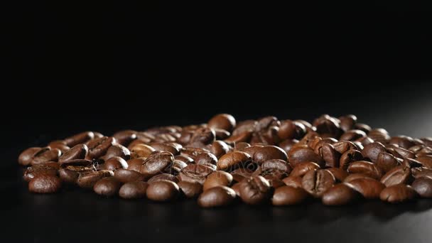 Siyah arka plan üzerine kavrulmuş kahve çekirdekleri döndürmek — Stok video