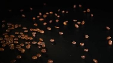 Kahve çekirdekleri - düşüyor. 96 Fps makro fotoğrafını kahve çekirdekleri siyah yüzeye düşüyor. Kahve için iyi bir genel çekim Temalar veya başlık arka planlar ile ilgili