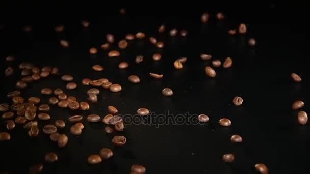 Coffee Beans - Falling. A 96 FpS macro shot of coffee beans falling on black surface. A beautiful generic shot for any coffee related themes or title backgrounds — Stock Video