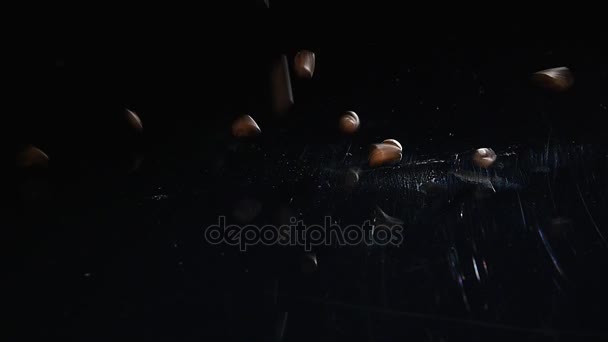 Coffee Beans - Falling. A 96 FpS macro shot of coffee beans falling on black surface. A beautiful generic shot for any coffee related themes or title backgrounds — Stock Video