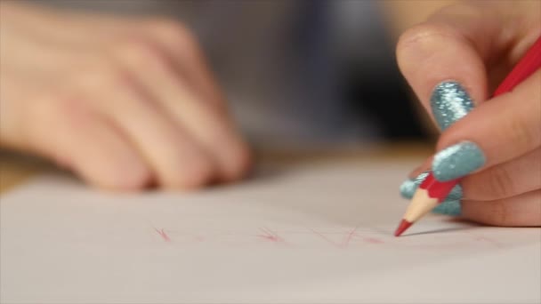 La fille dessine un croquis au crayon sur papier. Gros plan 