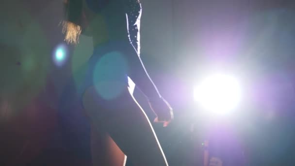 Gymnastka stojí proti spotlight — Stock video