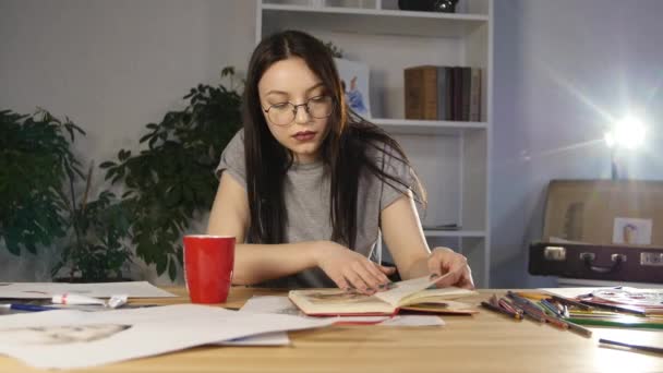 Aantrekkelijk meisje in glazen trekt tekent een portret met potloden — Stockvideo