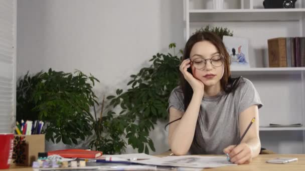 Chica atractiva en gafas dibuja un retrato con lápices — Vídeo de stock
