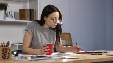 Gözlük berabere çekici kız ile kalemler bir portre çizer