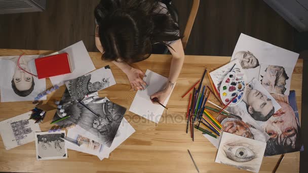 Вид сверху молодая девушка рисует карандашами — стоковое видео