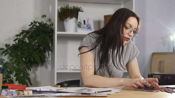 Menina atraente em óculos desenha um retrato com lápis — Vídeo de Stock