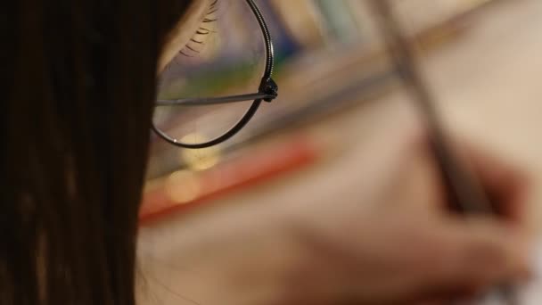 Дівчина в окулярах фотографії. вид зверху — стокове відео