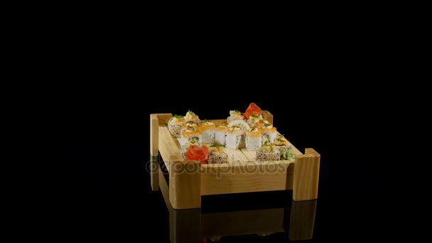 Набор суши вращается на черном фоне. вид сверху — стоковое видео